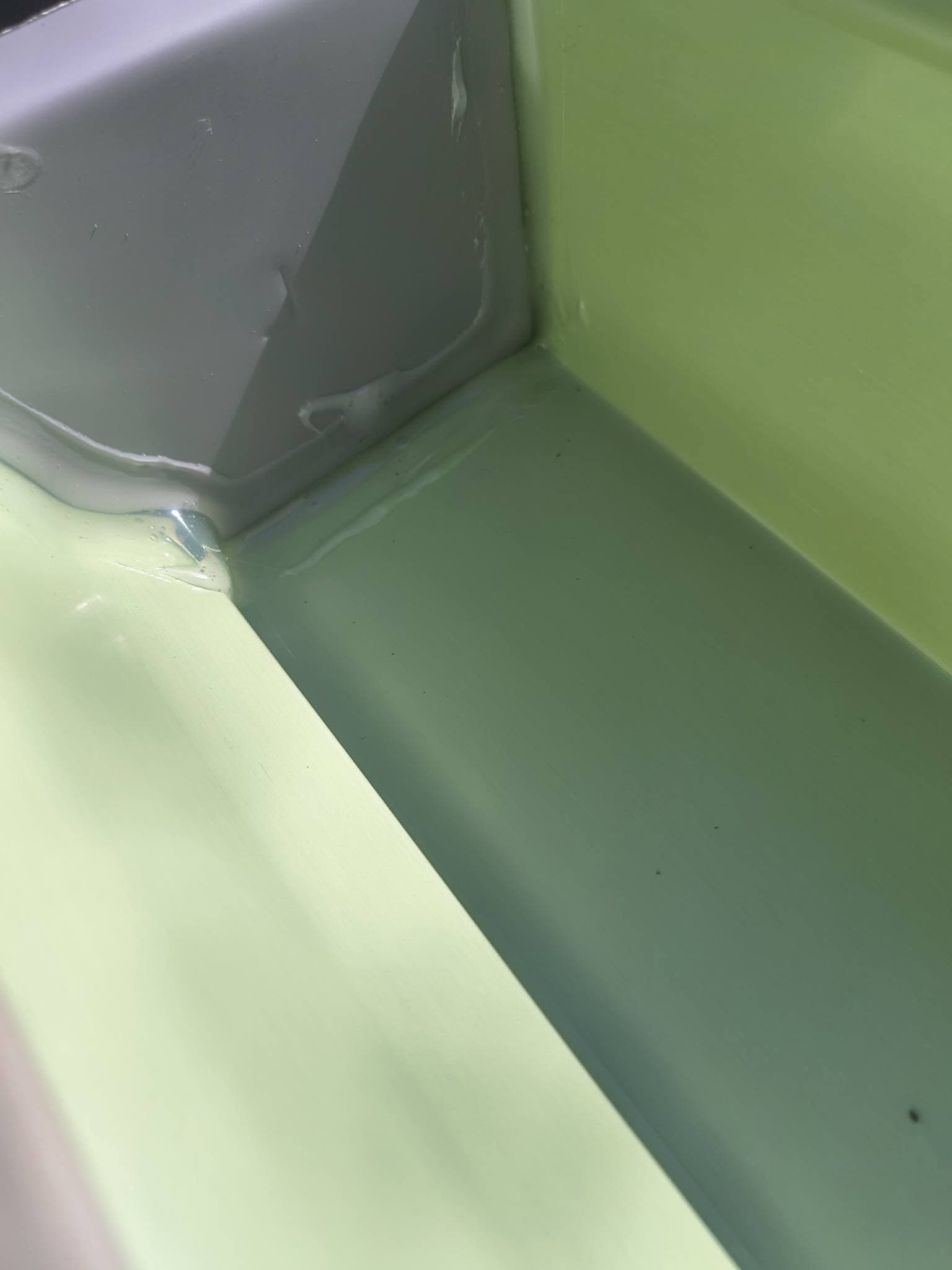 Close-up of a sealed inside-corner mitre in a green seamless gutter