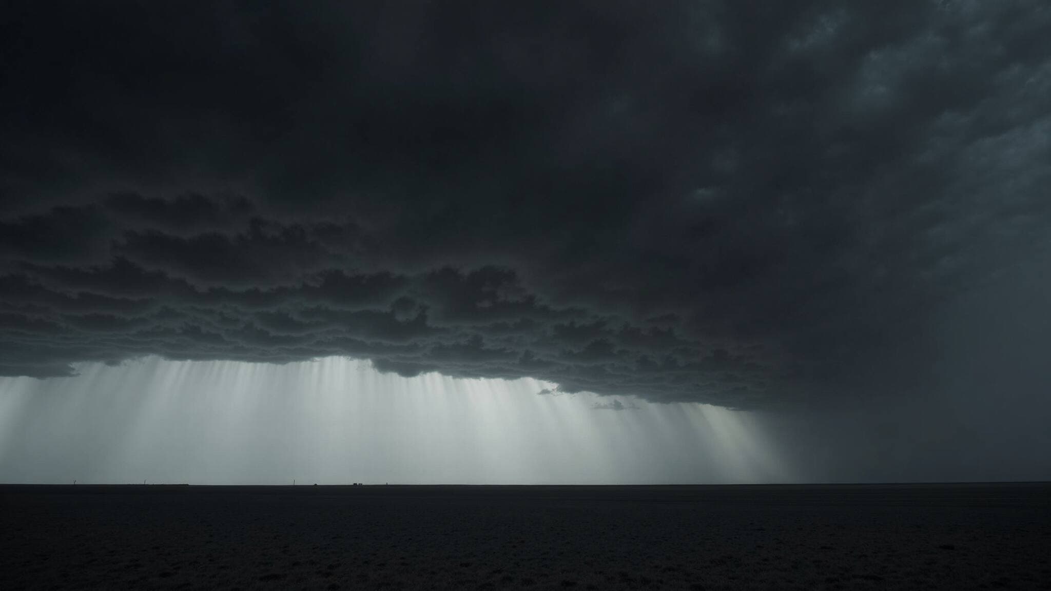 Illustrative storm front rolling over a flat prairie horizon under slate gray clouds