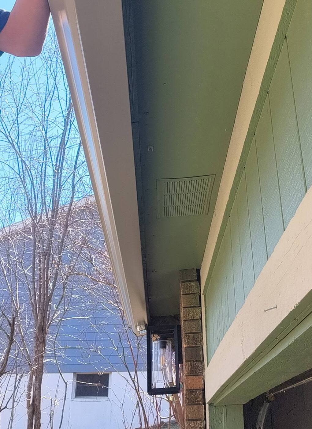 A new white seamless gutter run at the eave seen from below, used to preview coil colors